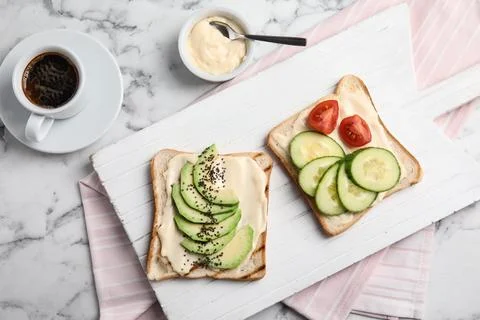 Slices of bread with different toppings on white marble table, flat lay Stock Photos