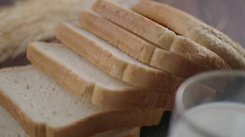 Slices of bread next to a glass of milk on a table Stock Footage 334764510