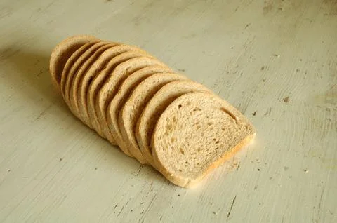 Slices of bread on old wooden table Stock Photos