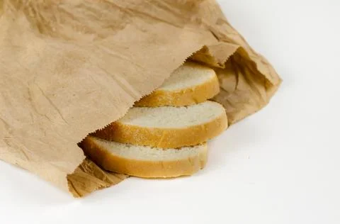 Slices of bread in a paper bag. Three slices of wheat bread in a brown lunch  Stock Photos