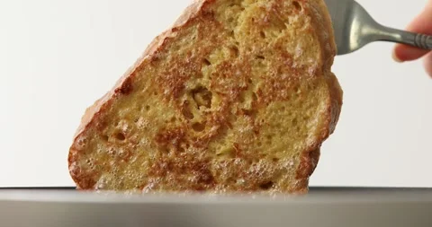 Slices of bread soaked in beaten egg are fried in a frying pan. Video stock 251680198