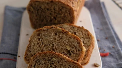 Slices bread from whole wheat flour, flax, sunflower and pumpkin seeds close-up Video stock 131275558