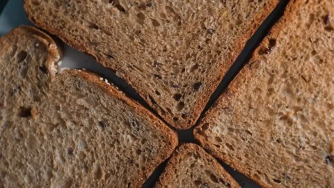 Slices of brown bread are arranged in a geometric pattern on a flat surface. Video stock 338297931