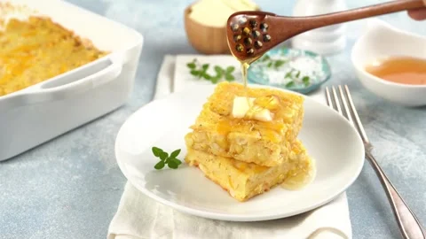 Slices of cheesy cornbread freshly baked served with butter and honey Stock Footage 242525706