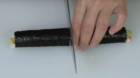Slices a cooked sushi roll into several pieces Stock Footage 132560716