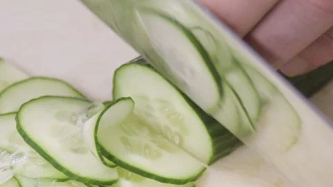Slices of cucumber on cutting board Stock Footage 104900874