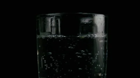 Slices of cucumber fall into the soda. Slow mo Stock Footage 75716631