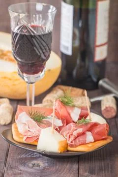 Slices of cured ham with melon and red wine Stock Photos