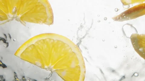 Slices of delicious orange fall down into water with bubbles Stockbeeldmateriaal 153003000