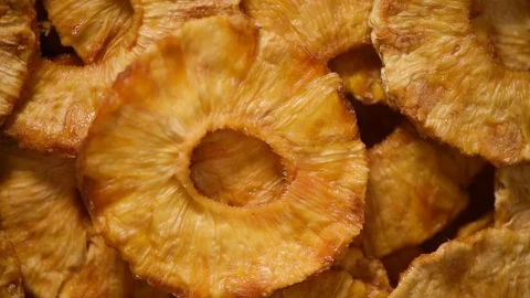 Slices of dried pineapple on rotating background. Top view. Vegan, vegetarian Stock Footage 125361861