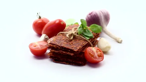 Slices of dried tomato fruit leather on a white background Stock Footage 345337103