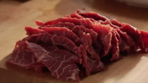 Slices a Flat Iron steak and chef placing the slices on a plate Stock Footage 98247789