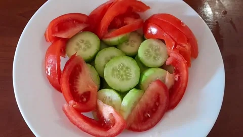 Slices of fresh bright green cucumbers and ripe tomatoes salad Stock Footage 342435320