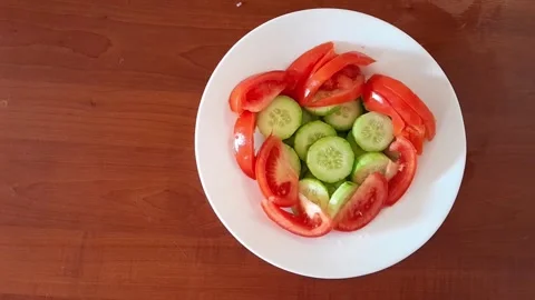 Slices of fresh bright green cucumbers and ripe tomatoes salad Stock Footage 342435331