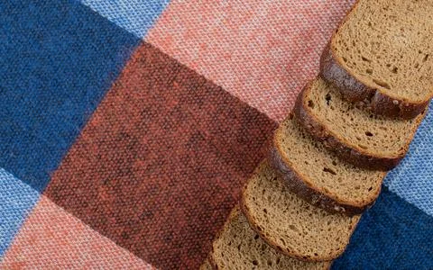 Slices of fresh brown bread on a tablecloth Stock Photos