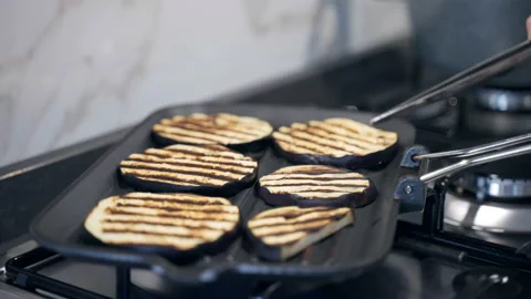 Slices of fresh eggplants grilling without oil on grill pan in trendy kitchen Stock Footage 159602645