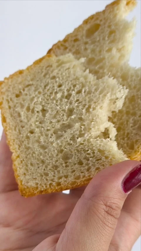 Slices of fresh white bread in the hands of a woman on a white background Video stock 311654094