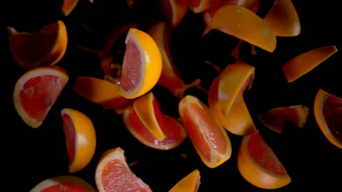 Slices of grapefruit with juise flies to the camera Stock Footage 88490212