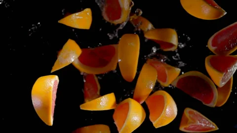 Slices of grapefruit with water flies to the camera Stock Footage 88490166