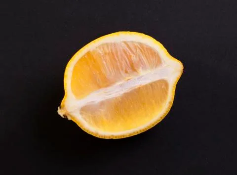 Slices of half a lemon on a black background Stock Photos