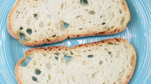 Slices of Italian artisan rustic soft wheat bread from Lazio region, on blue Stock Footage 342188867