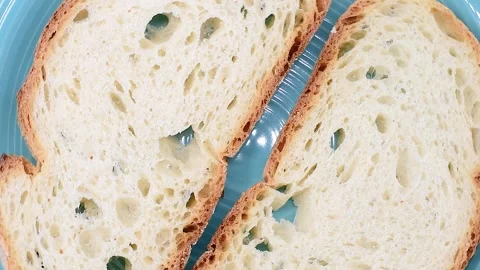 Slices of Italian artisan rustic soft wheat bread from Lazio region, on blue Stock Footage 342190057