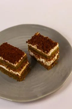 Slices of layered cake featuring alternating dark spiced cake layers and creamy Stock Photos