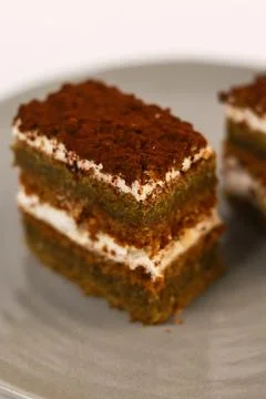 Slices of layered cake featuring alternating dark spiced cake layers and creamy Stock Photos