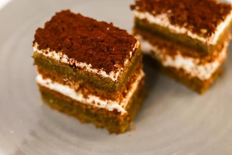 Slices of layered cake featuring alternating dark spiced cake layers and creamy Stock Photos