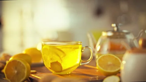 Slices of lemon and ginger are artistically swirling in a transparent cup in Stock Footage 331361919