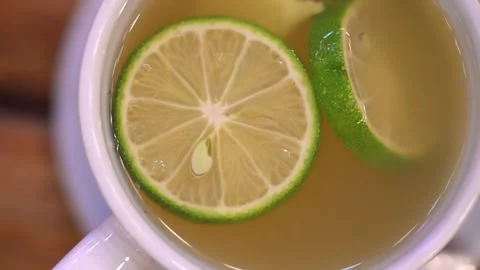 Slices of lemon and ginger infusing in hot water Vídeo Stock 316134103