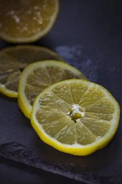 Slices of lemon on a black background. Selective focus. Stock Photos