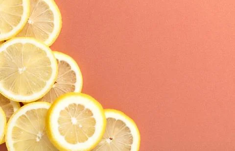 Slices of lemon on salmon background Foto stock