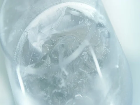 Slices of lime fallind in an iced spinning drink Stock Footage 76677518