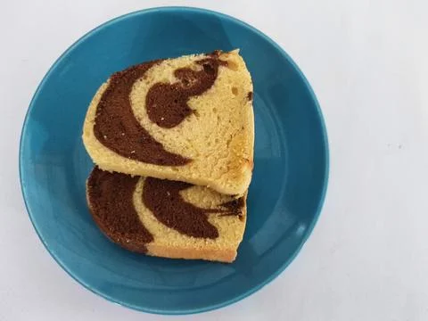 Slices of Marble Sponge Cake on Blue Plate. Delicious Sweet Swirl Dessert Stock Photos
