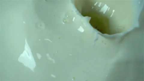 Slices of orange and kiwi fall into milk in slow motion Stock Footage 126898397