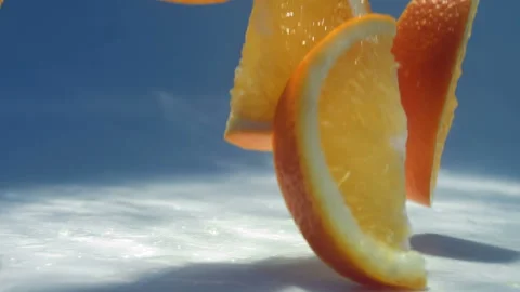 Slices of orange fall on the white table Stock Footage 88491414