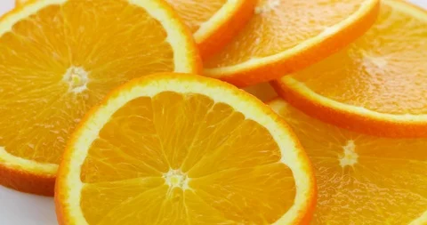 Slices of orange rotating on white background Stock Footage 102412799