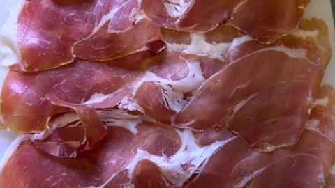 Slices of parma ham on white cutting board Stock Footage 311947989