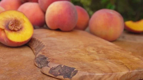 Slices of peaches falling on the wooden table Stock Footage 74110662