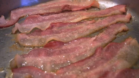 Slices of pork bacon is prepared in its own fat. Layers of meat and lard. 스톡 동영상 334642291
