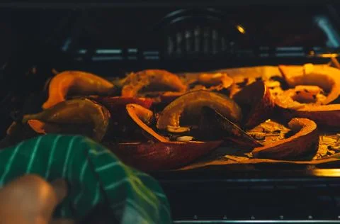 Slices of pumpkin on the baking sheet put into the oven Stock Photos