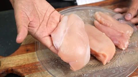 Slices of Raw chicken meat on board in kitchen room Stock Photos