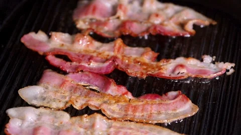 Slices of raw pork bacon is prepared in its own fat. fat bacon strips sizzle. 스톡 동영상 334642784