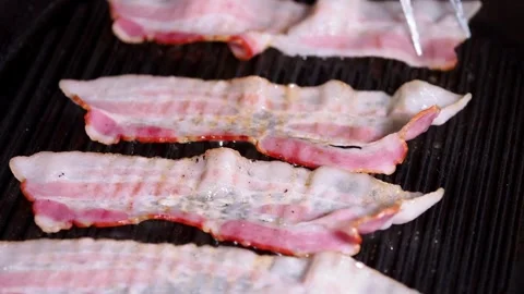 Slices of raw pork bacon is prepared in its own fat. fat bacon strips sizzle. 스톡 동영상 334643255