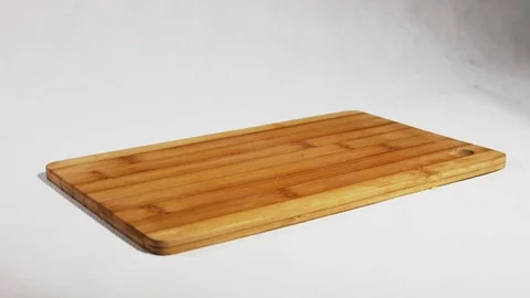 Slices of red bell pepper drops to the wooden board in slow motion Video stock 70710153