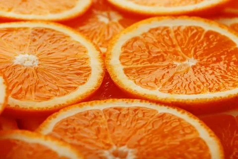 Slices of ripe orange backlit as a textural background. Full screen, close-.. Stock Photos
