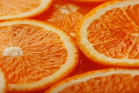 Slices of ripe orange backlit as a textural background. Full screen, close-.. Stock Photos