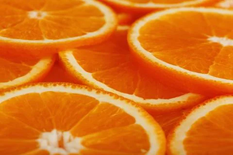 Slices of ripe orange backlit as a textural background. Full screen, close-.. Stock Photos