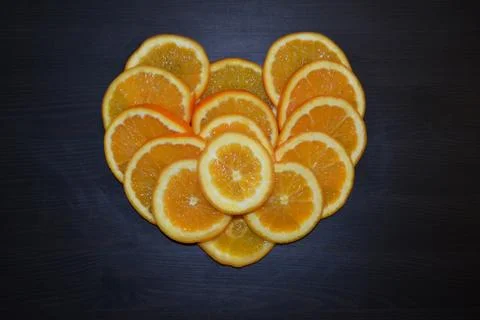 Slices of ripe oranges posed in a shape of a heart. Stock Photos
